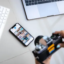 Person taking pictures of cell phone on desk with images on it with a camera