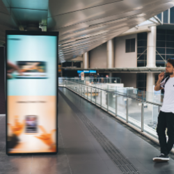 Digital Signage in Mall with man leaned up against railing by it